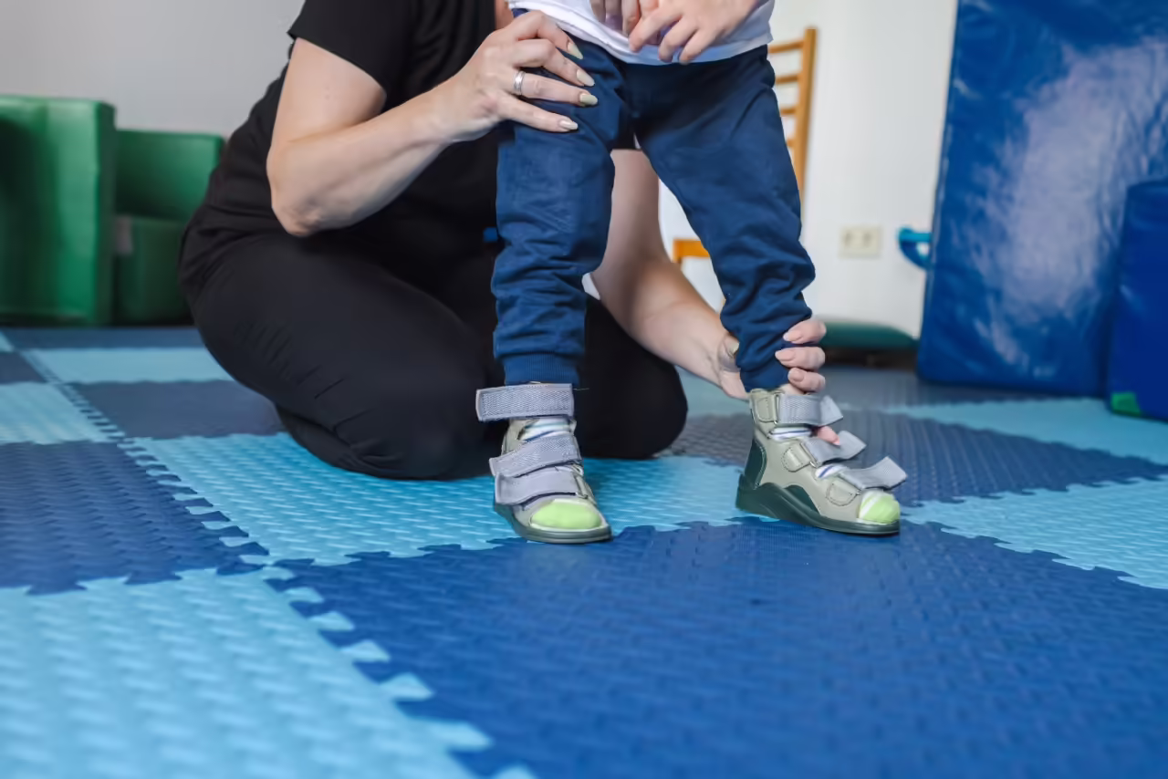 adult helping a child with supportive footwear 2026 03 24 03 23 38 utc