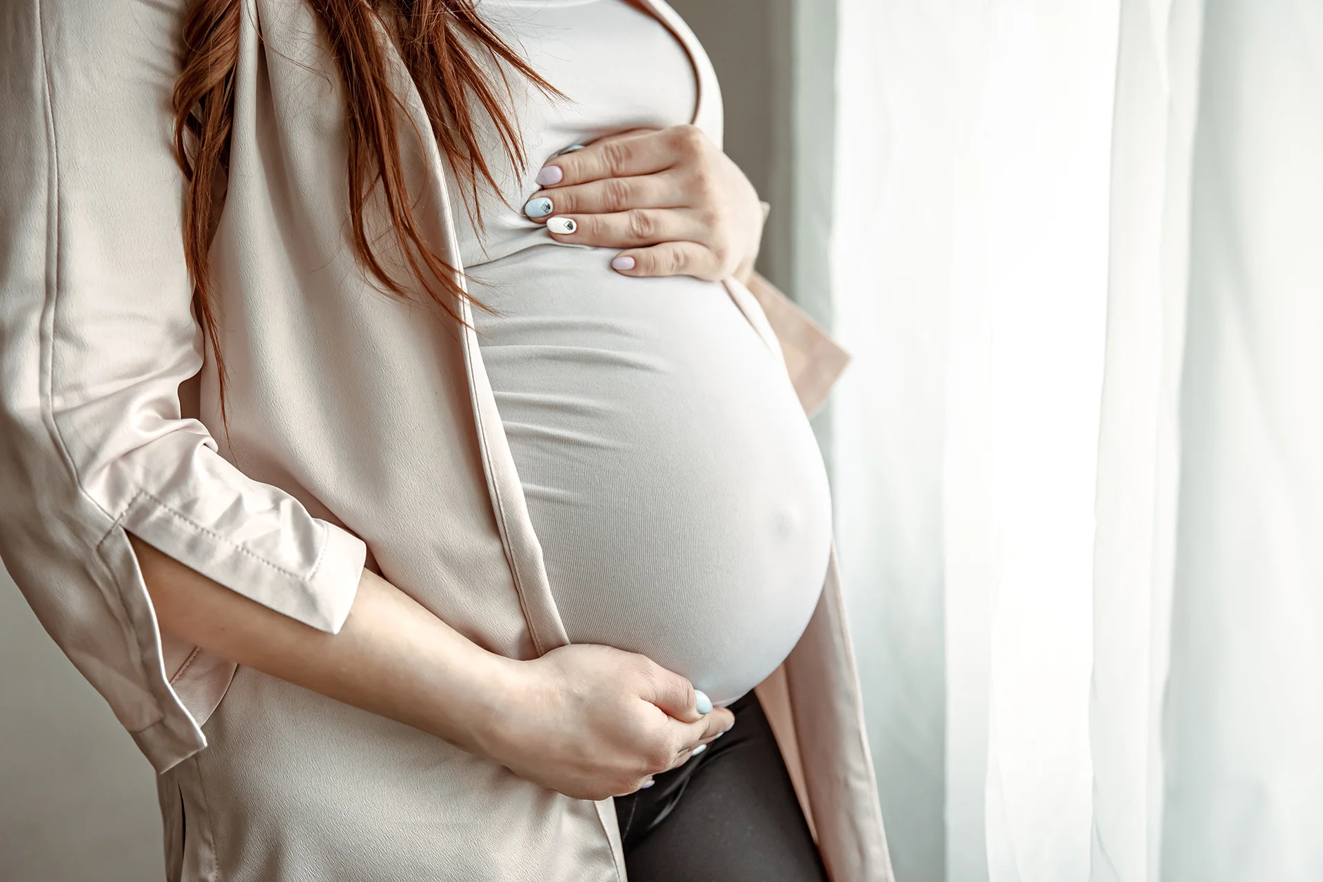 close up of belly of a pregnant woman standing